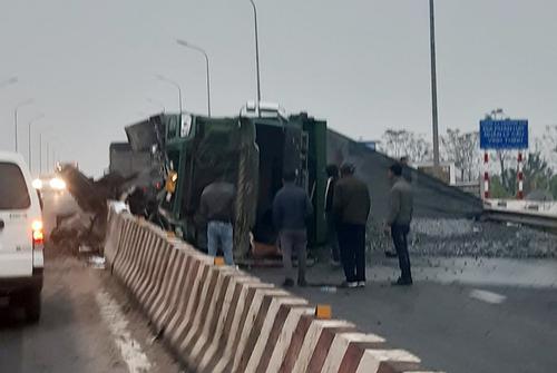 Tài xế xe ben chở đất đá mất lái, tông vào dải phân cách khiến xe lật ngang trên QL2C
